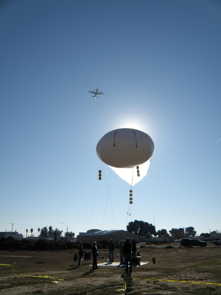 NASA P3-B flying over a tethered rheostat balloon in Huron, California during the 2013 California DISCOVER-AQ deployment.